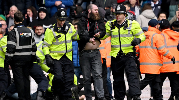 A pitch invader is escorted from the pitch by local police as the game is postponed during the Emirates FA Cup Fourth Round match between West Bromwich Albion and Wolverhampton Wanderers at The Hawthorns on January 28, 2024 in West Bromwich, England. (Photo by Shaun Botterill/Getty Images)