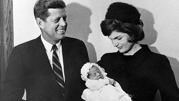 John F Kennedy and his wife Jackie with his namesake son, taken days before the assassination attempt at the baby's baptism.