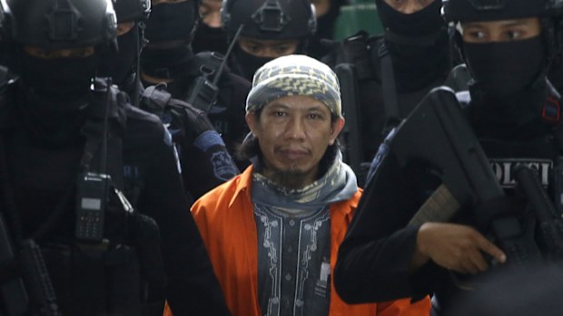 Members of Indonesian police counter terrorism unit Special Detachment 88 escort radical cleric Aman Abdurrahman upon arrival for his trial at a district court in Jakarta, Indonesia, Friday, May 25, 2018. (AAP)