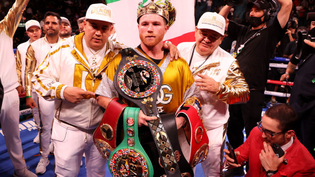 Canelo Alvarez poses with the belts after his championship bout for Alvarez's WBC, WBO and WBA super middleweight titles and Plant's IBF super middleweight title