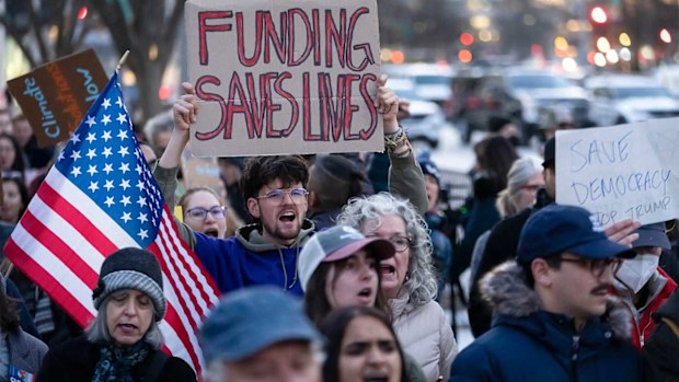 Protesters opposing Donald Trump's funding freeze outside the White House.