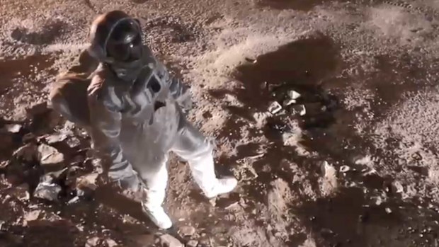 Poornachandra Mysore walks down a street in Bangalore dresses as a spaceman.