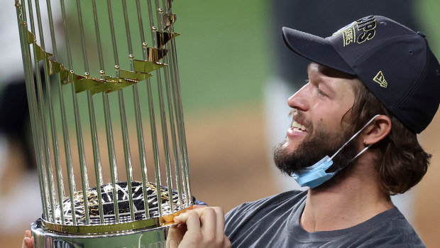 Clayton Kershaw #22 of the Los Angeles Dodgers celebrates with the Commissioners Trophy
