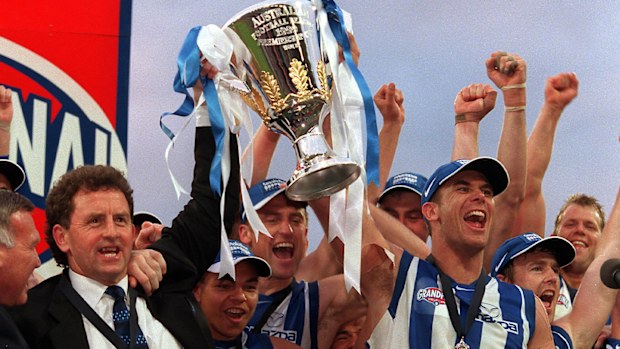 Denis Pagan lifts 1999 premiership cup with Wayne Carey and Kangaroos team