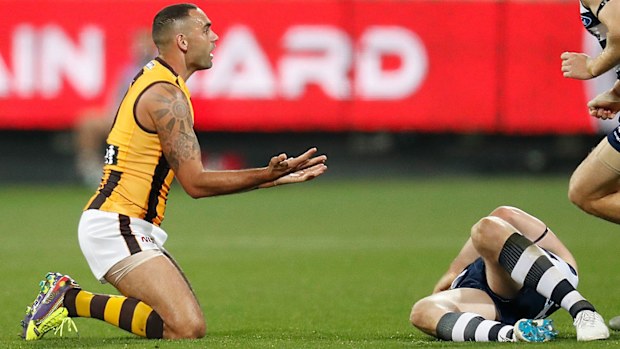 Patrick Dangerfield of the Cats lays injured after being tackled by Shaun Burgoyne of the Hawks