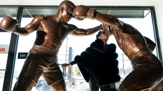 Weatta Frazier Collins kisses a statue of her father Joe Frazier, right, fighting Muhammad Ali, on the 50th anniversary of the boxers' World Heavyweight championship boxing bout.