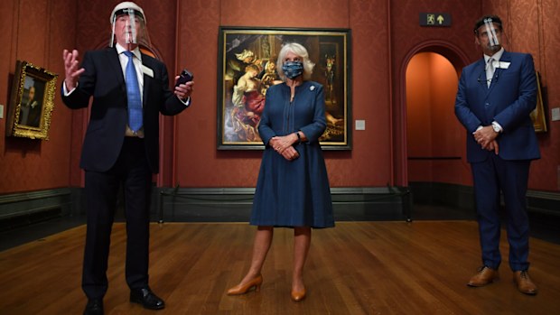 Chair of the Board of Trustees Tony Hall (L) gives a speech as Camilla, Duchess of Cornwall (C) and National Gallery Director Gabriele Finaldi look on during a visit to the recently reopened National Gallery on July 28, 2020 in London, England