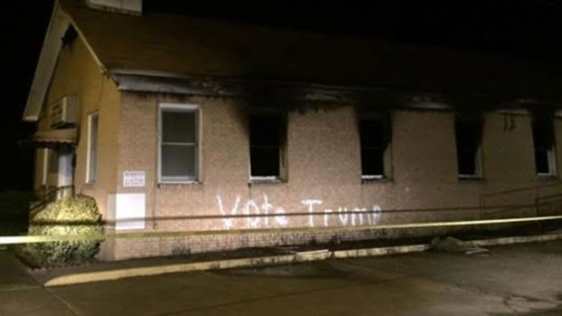 The burned church with the slogan painted on the side.