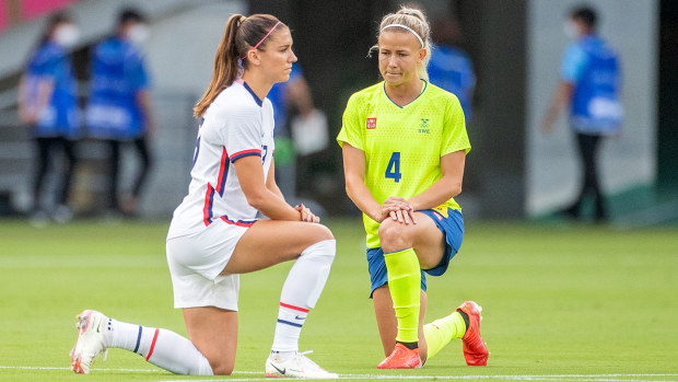  Alex Morgan. #13 of the United States and Hanna Glas #4 of Sweden take a knee before the start of the USA V Sweden group G football match at Tokyo Stadium during the Tokyo 2020 Olympic Games on July 21, 2021 in Tokyo, Japan. (Photo by Tim Clayton/Corbis via Getty Images)