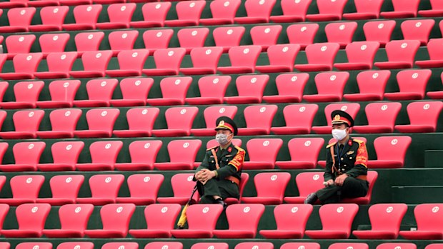 Vietnamese police officers wearing masks are seen in the stand as the game is held behind closed doors