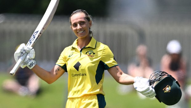 Ashleigh Gardner raises her bat after striking a century against England.