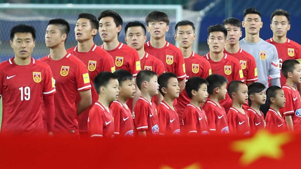Footballers stand for the Chinese national anthem. (AAP)