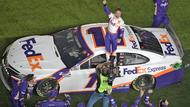 Denny Hamlin (11) celebrates in front of the grandstands after winning the NASCAR Daytona 500 auto race