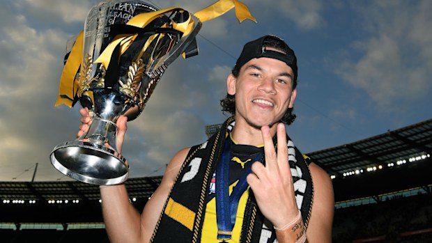 Daniel Rioli of the Tigers celebrates with the Premiership Trophy 