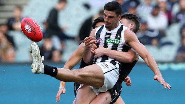 Scott Pendlebury of the Magpies is tackled by Sam Walsh of the Blues
