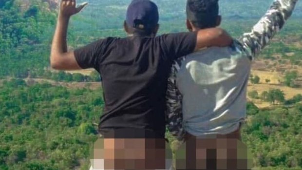 This photo from Sri Lankan police shows two of the men with bare bums on the sacred Pidurangala Rock.