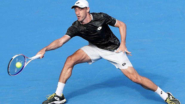 John Millman of Australia hits a return shot against Lloyd Harris of South Africa