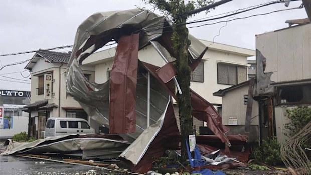 A metal object blown away by strong winds of a typhoon is caught on a power line in Miyazaki, western Japan, Thursday, August 29, 2024.