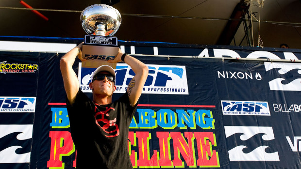 Mick Fanning of Australia hoists his ASP World Title trophy after winning his second ASP World Title at the Billabong Pipeline Masters on December 12, 2009