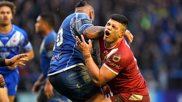 Tonga's David Fifita is tackled by Samoa's Junior Paulo during their Rugby League World Cup quarterfinal.