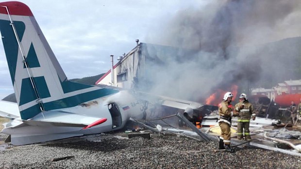 Fire fighters at the site of the crash of an Antonov-24 passenger plane, which burst into flames after crash landing into a sewage treatment plant during an emergency landing.