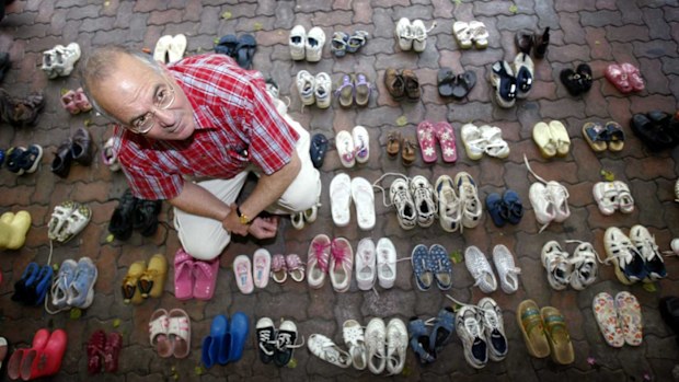 Tony Kevin, author of "A Certain Maritime Incident", sits amongst the 146 pairs of shoes, with each pair representing a child that drowned when the ship Siev-X sank on its way to Christmas Island.