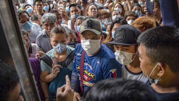 Filipinos hoping to buy face masks crowd outside a medical supply shop that was raided by police for allegedly hoarding and overpricing the masks, as public fear over China's Wuhan Coronavirus grows, on January 31, 2020 in Manila, Philippines.
