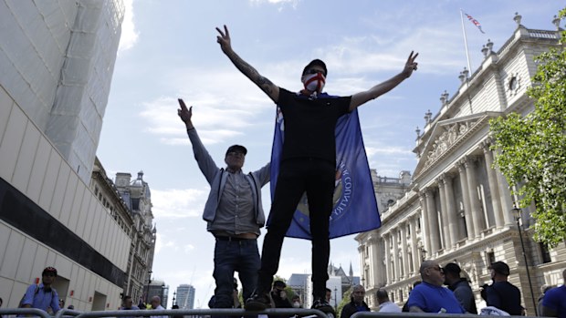 Members of Football Lads Alliance, standing at a police barrier along Whitehall, in central London, chant slogans, Saturday, June 13, 2020