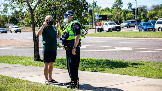 A man talks to a policeman outside a COVID-19 testing station at Marrara Sport Complex in Darwin.