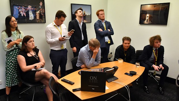 Australian Associated Press journalists look on as bureau chief Paul Osbourne (C) holds his head after being that AAP will be closing on June 26th at Parliament House in Canberra