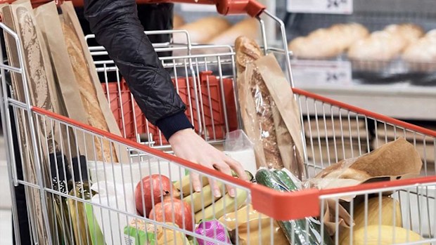 Woman filling trolley with groceries