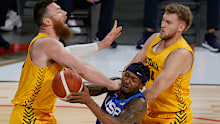 Bradley Beal of the US drives into Aron Baynes of the Australia Boomers as Jock Landale closes in.