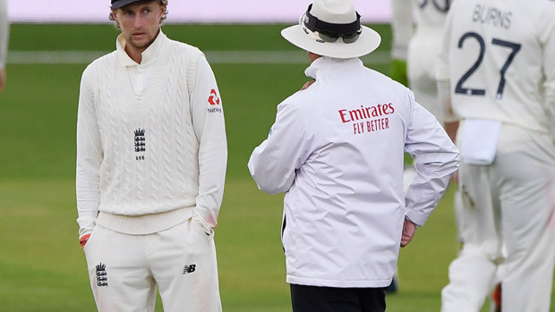 Joe Root speaks to umpire Richard Illingworth as bad light finally stops play on day three of the third Test.