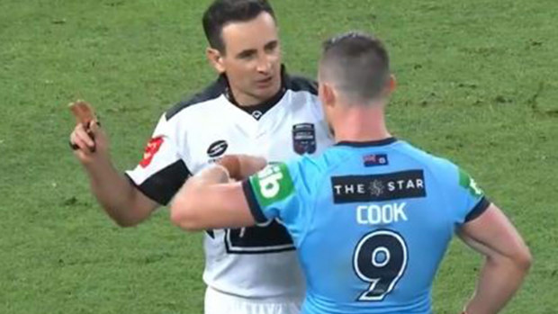 Referee Gerard Sutton explains the ruling to NSW hooker Damien Cook.