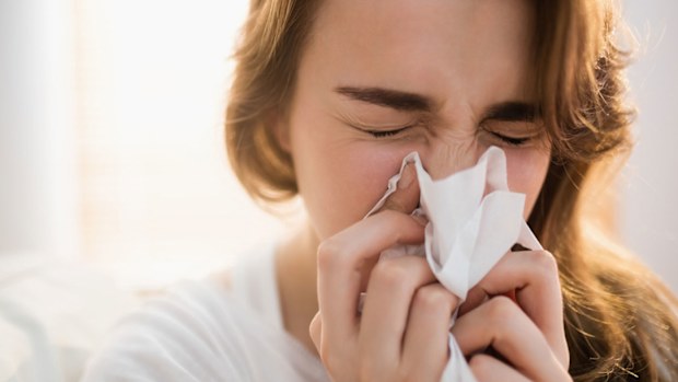 Woman sneezing / blowing her nose (hay fever / COVID-19 symptoms)