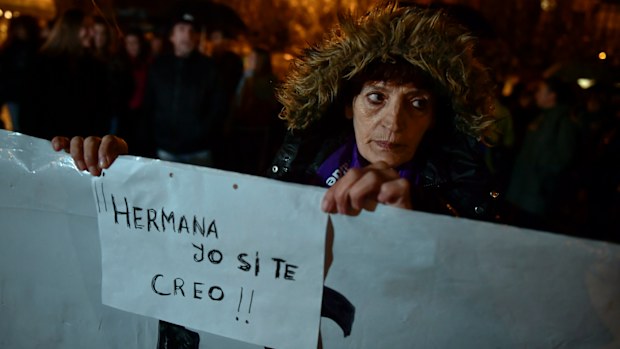 A woman holds a sign reading ''Sister. I believe you'' as people gather at Plaza del Castillo square to a protest against sex assault, in Pamplona, northern Spain, Monday, Nov. 4, 2019. 