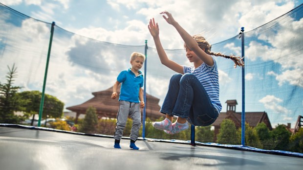 Boy and girl jumping on trampoline