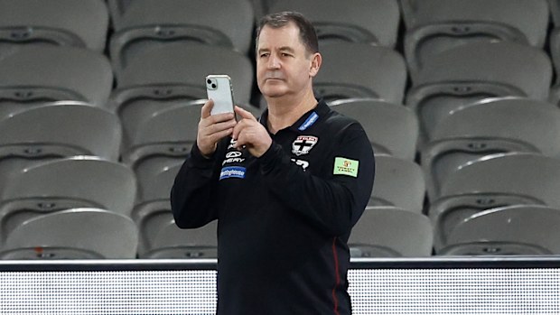Ross Lyon, Saints'in baş antrenörü, ıslak sahadan Twitter'a gönderi yaparken görülüyor.