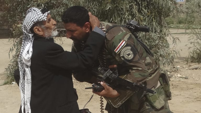 Thank you: A man kisses an Iraqi soldier after security forces pushed out Islamic State terrorists from villages outside Ramadi, Iraq, on Wednesday.