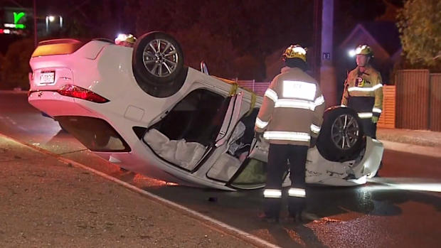 The car was flipped on its roof after crashing through the roundabout.