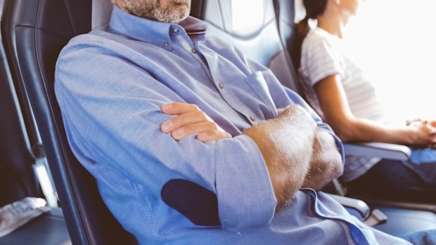 Mid adult man sitting in the aircraft and having a nap.