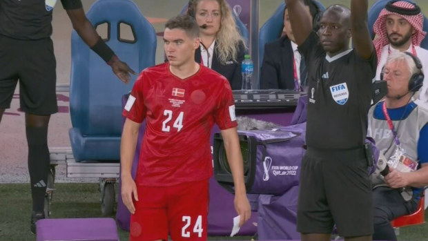 Danish forward Robert Skov preparing to come onto the field against the Socceroos holding a note to give to captain Christian Eriksen.