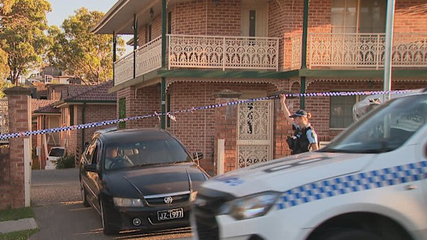 Police tape and a police car outside a Greenacre home in Sydney's south-west following reports of gunshots. 