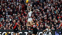 Jamie Elliott of the Magpies takes a spectacular mark over Ben McKay of the Bombers during the annual Anzac Day clash.
