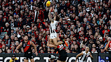 Jamie Elliott of the Magpies takes a spectacular mark over Ben McKay of the Bombers during the annual Anzac Day clash.