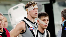 Tom Jonas and Zak Butters are seen waiting to come back on to the ground after clashing heads with each other.