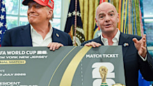 US President Donald Trump, left, and Gianni Infantino, president of the Federation International Football Association (FIFA), hold a ticket to the final 2026 FIFA World Cup match in the Oval Office of the White House in Washington, DC, US, on Friday, Aug. 22, 2025. Trump announced that Washington's John F. Kennedy Center for the Performing Arts will host the draw for the 2026 FIFA World Cup. Photographer: Annabelle Gordon/UPI/Bloomberg