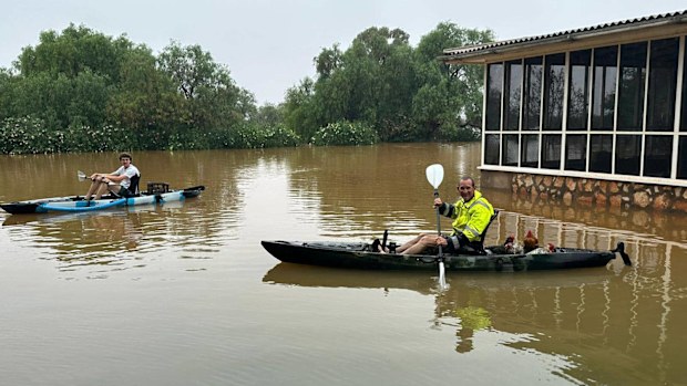 A station worker is seen paddling chickens to safety at Rawlinna Station WA