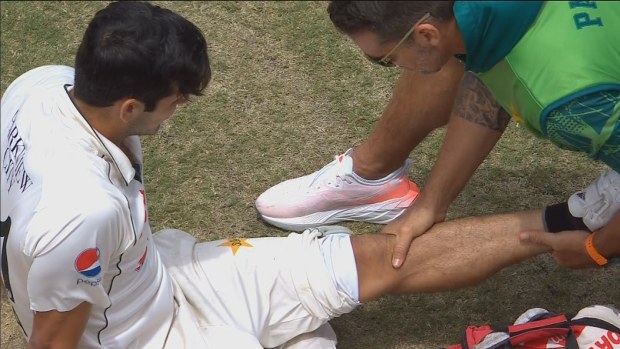 A physio attends to Mir Hamza after he fell on his knee.