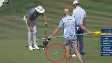 Austin Eckroat and Joel Dahmen watch Eckroat's ball as it teeters on the edge of the cup.